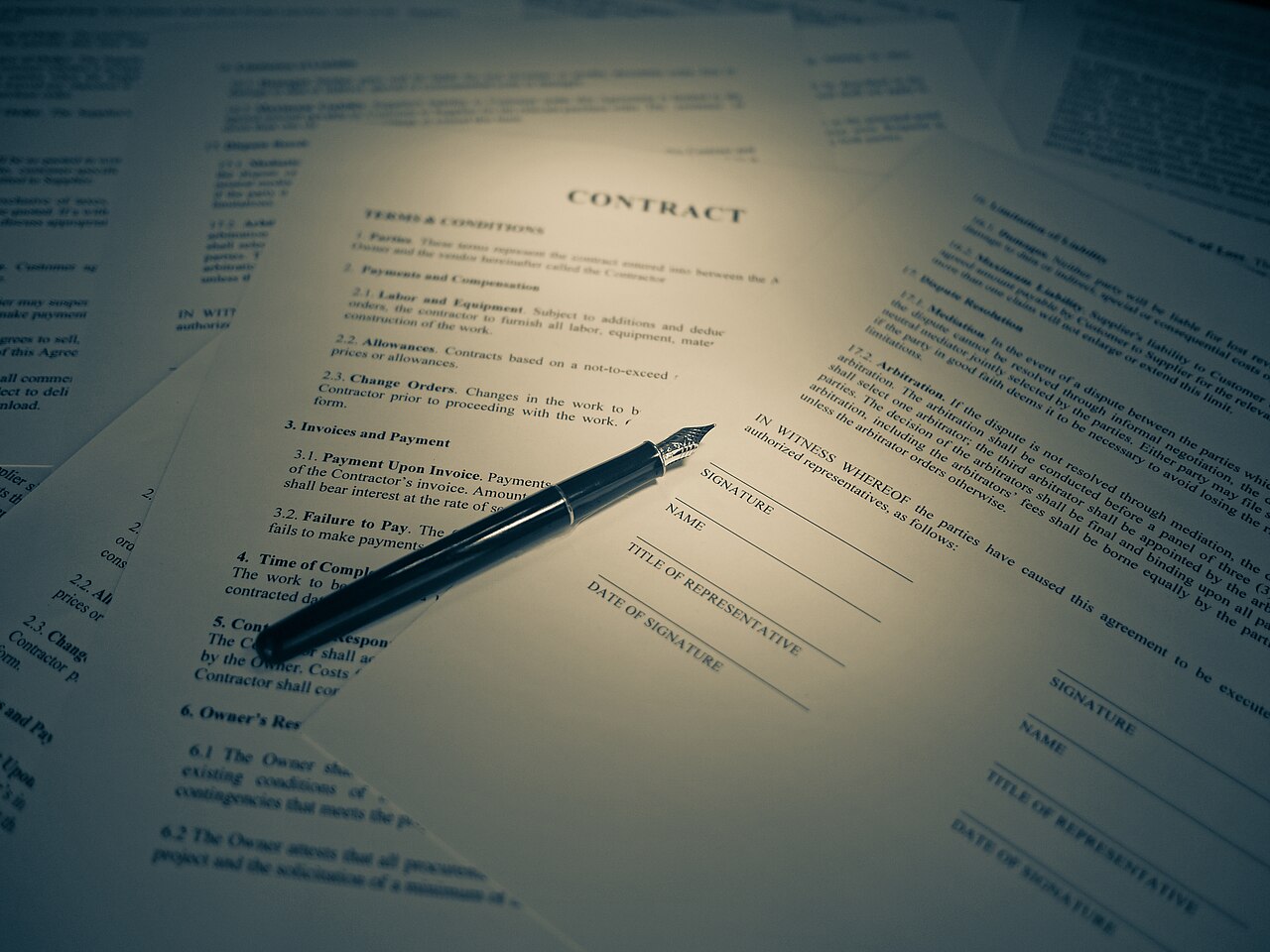 Documento legal con una pluma sobre la firma